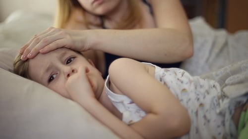 Caring Mother Checks Temperature of Sick Child