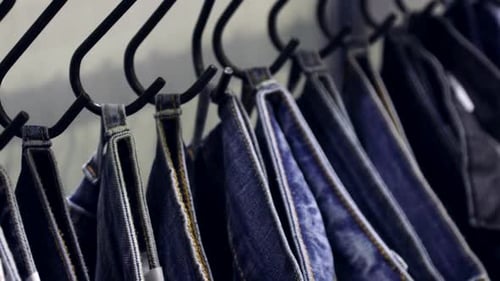 Close-up of blue jeans hanging on rack