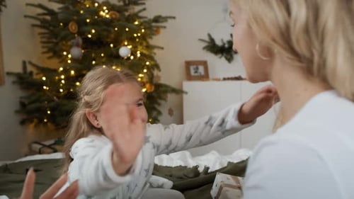 Mother and Daughter Share Christmas Gift and Embrace