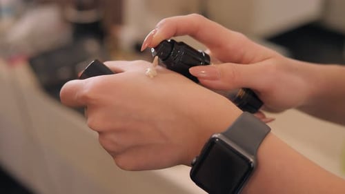 Woman Pumps Makeup onto Hand Close Up