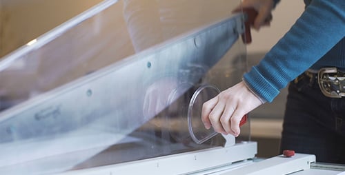 Woman Cutting Paper Using a Paper Cutter
