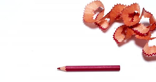 Red Pencil with Pencil Shavings on White Surface