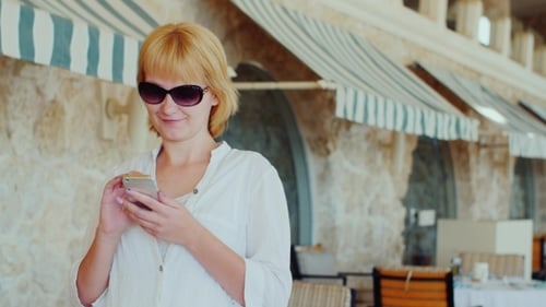 Attractive Woman Writing Sms On a Background Of a Typical Italian Restaurant