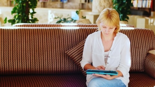Attractive Woman Working On a Tablet In The Hotel Lobby