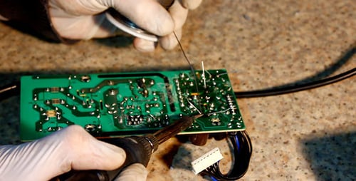 Close Up Soldering Circuit Board with Gloves