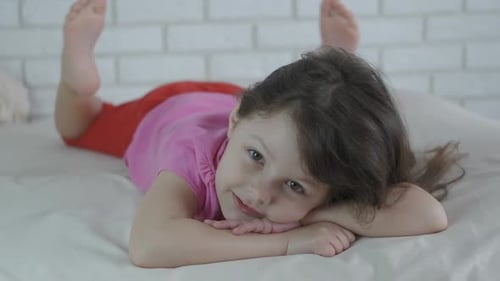 Smiling Child Lying on Bed