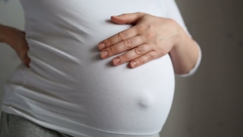 Pregnant Woman With Hand on Baby Belly