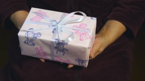 Hands Deliver Birthday Gift Wrapped with Bow