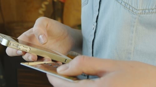 Weibliche Hände kaufen Waren aus dem Internet auf seinem Smartphone mit seiner Kreditkarte.