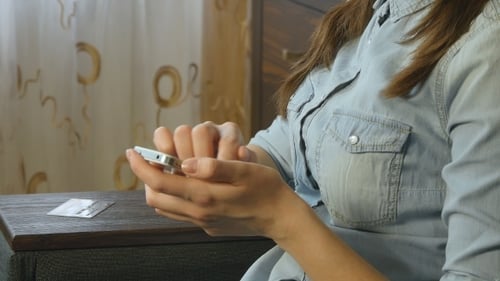 Woman Using Smartphone Indoors with Credit Card