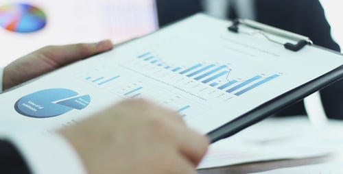 Professional Men Reviewing Charts in Workplace Setting