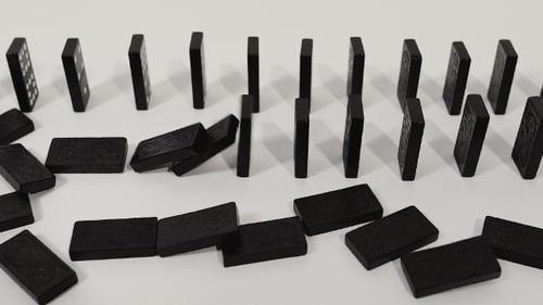 Dominoes Falling in a Line on White Surface
