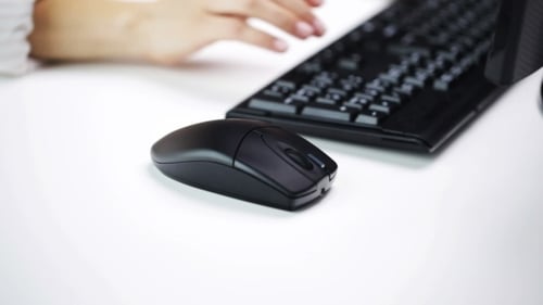 Frau tippt auf Computertastatur im Büro