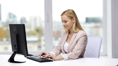 Young Businesswoman With Computer Typing At Office