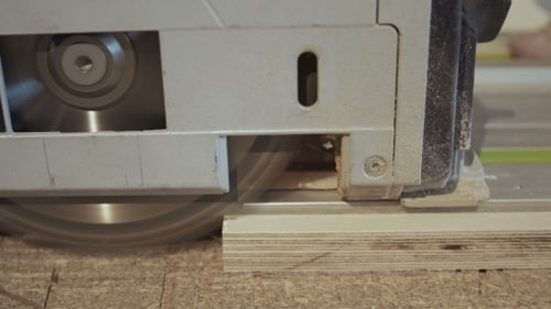 Man Carpenter schneidet ein Stück Holz mit einer Handkreissäge