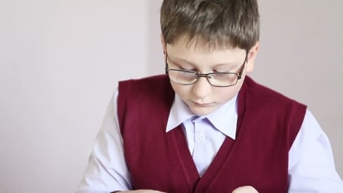 Junge mit Brille spielt in der Schule auf dem Tablet