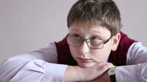 Pensive Boy with Glasses Resting Head on Hands
