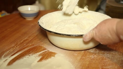Mixing Dough in Bowl on Flour Covered Table