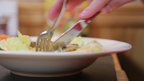 Man Eating a Salad With Fork And Knife