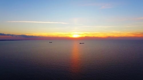 Two Boats Floating In The Sea At Sunset