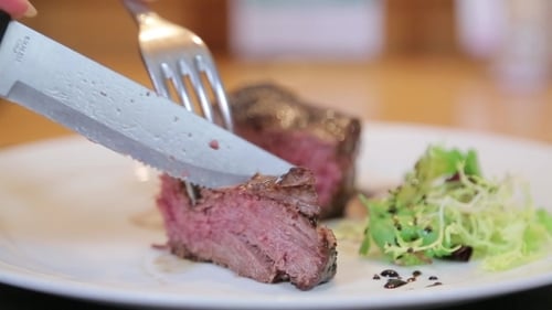 Slicing Medium Rare Steak with Knife and Fork