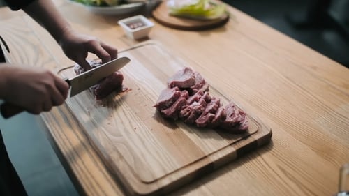 Meat Sliced on a Wooden Cutting Board