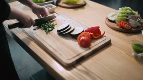 Chef Prepares Fresh Vegetables on Wooden Cutting Board