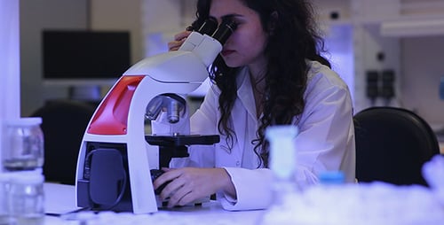 Woman Scientist Using Microscope in a Lab