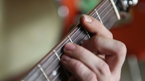 Hand Playing Chords on Acoustic Guitar Close Up