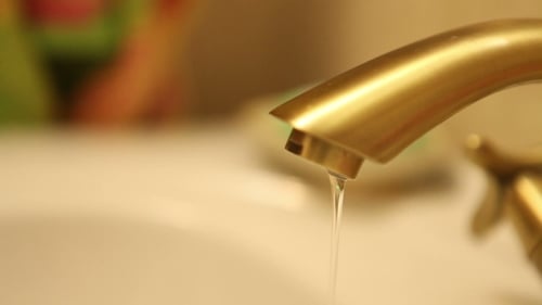 Water Dripping From Golden Faucet Close Up