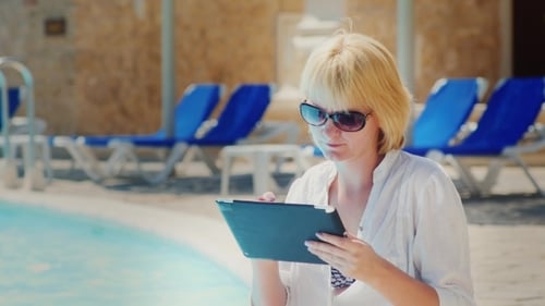 Woman In Sunglasses Enjoys The Tablet Pool