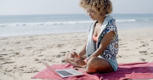 Frau mit Laptop am Sommerstrand