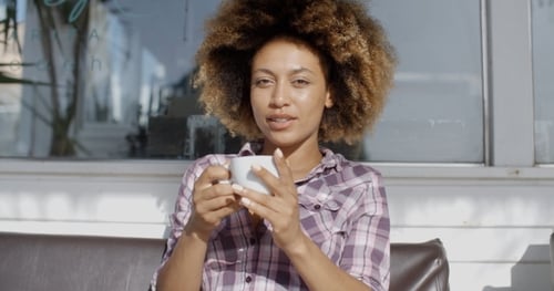 Woman Sitting At A Cafe And Drinks A Coffee
