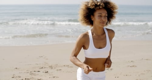 Woman Jogging On The Beach