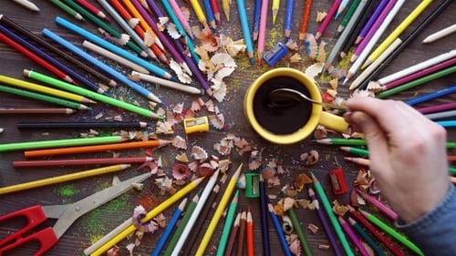 Colorful Pencils, Coffee, and Art Supplies on Table