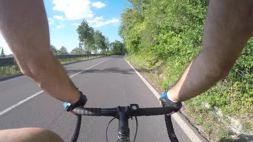 Homme à vélo en montée et escalade sur route par une journée ensoleillée