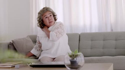 Middle Aged Woman Rubbing Neck in Pain