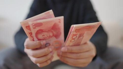 Hands Counting Renminbi Money in an Indoor Setting