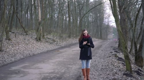 Hermosa chica en el bosque de primavera con tableta.