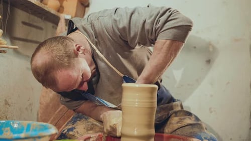 View of Manly Potter Making Ceramic Dish in Workshop, Using Potter's Wheel