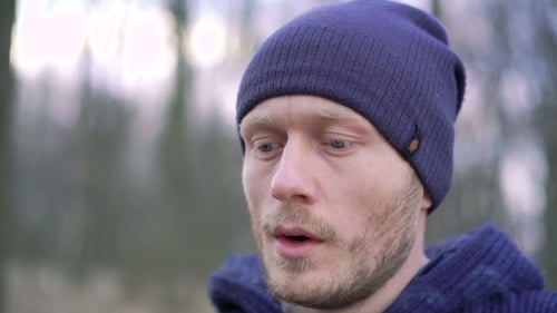 Un jeune homme fume une cigarette dans la forêt