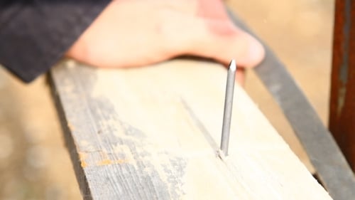 Frapper un clou d'une planche
