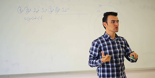 Man Explains Science Lesson at Whiteboard