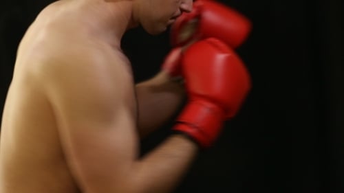 Shirtless Man Boxing with Red Gloves