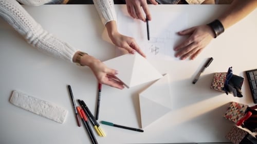 Deux architectes discutent du plan ensemble au bureau avec des plans
