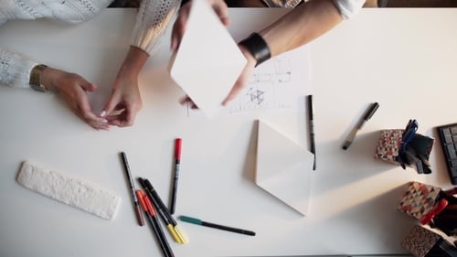 Architects Collaborate on Building Design Plans at Table