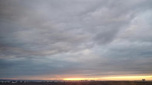 Sunrise Under a Dramatic Cloudscape Over City