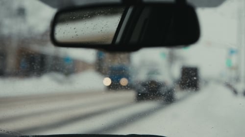 Autos fahren auf einer verschneiten Straße. Die Spiegelung im Rückspiegel