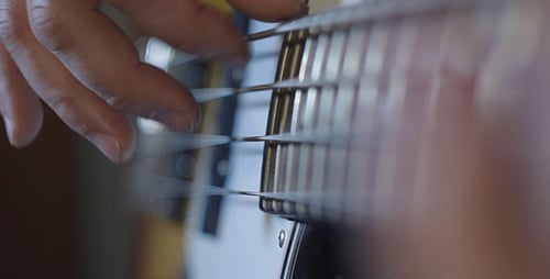 Fingers Pluck Bass Guitar Strings in Close Up