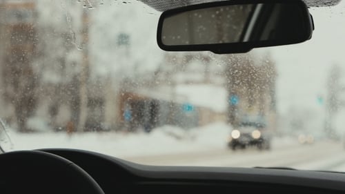 Autos fahren auf einer verschneiten Straße. Die Spiegelung im Rückspiegel